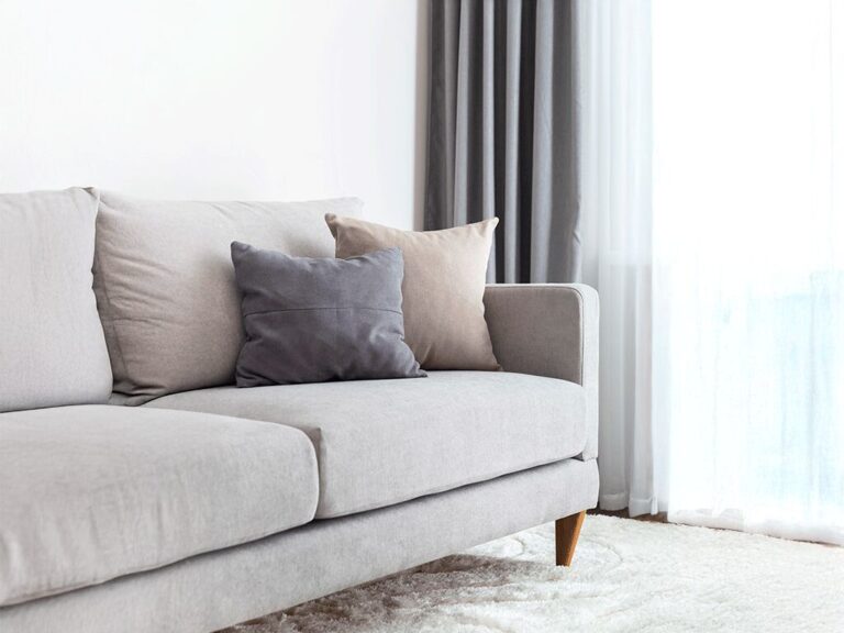 Sofá cinza com almofadas em sala minimalista