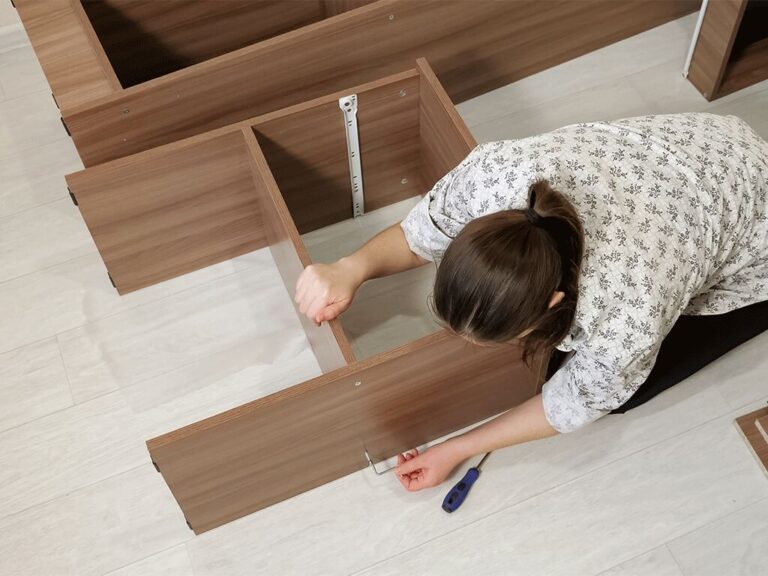 Pessoa montando móvel de madeira com ferramentas